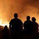 People watch a wildfire raging near houses in the outskirts of Obidos, Portugal, in the early hours of Monday, Oct. 16 2017. Photo: AP